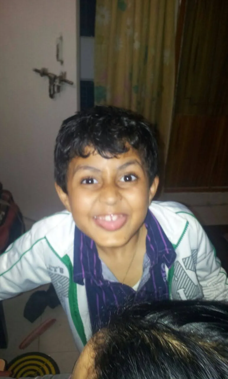 A childhood photograph of Aarush smiling at the camera.