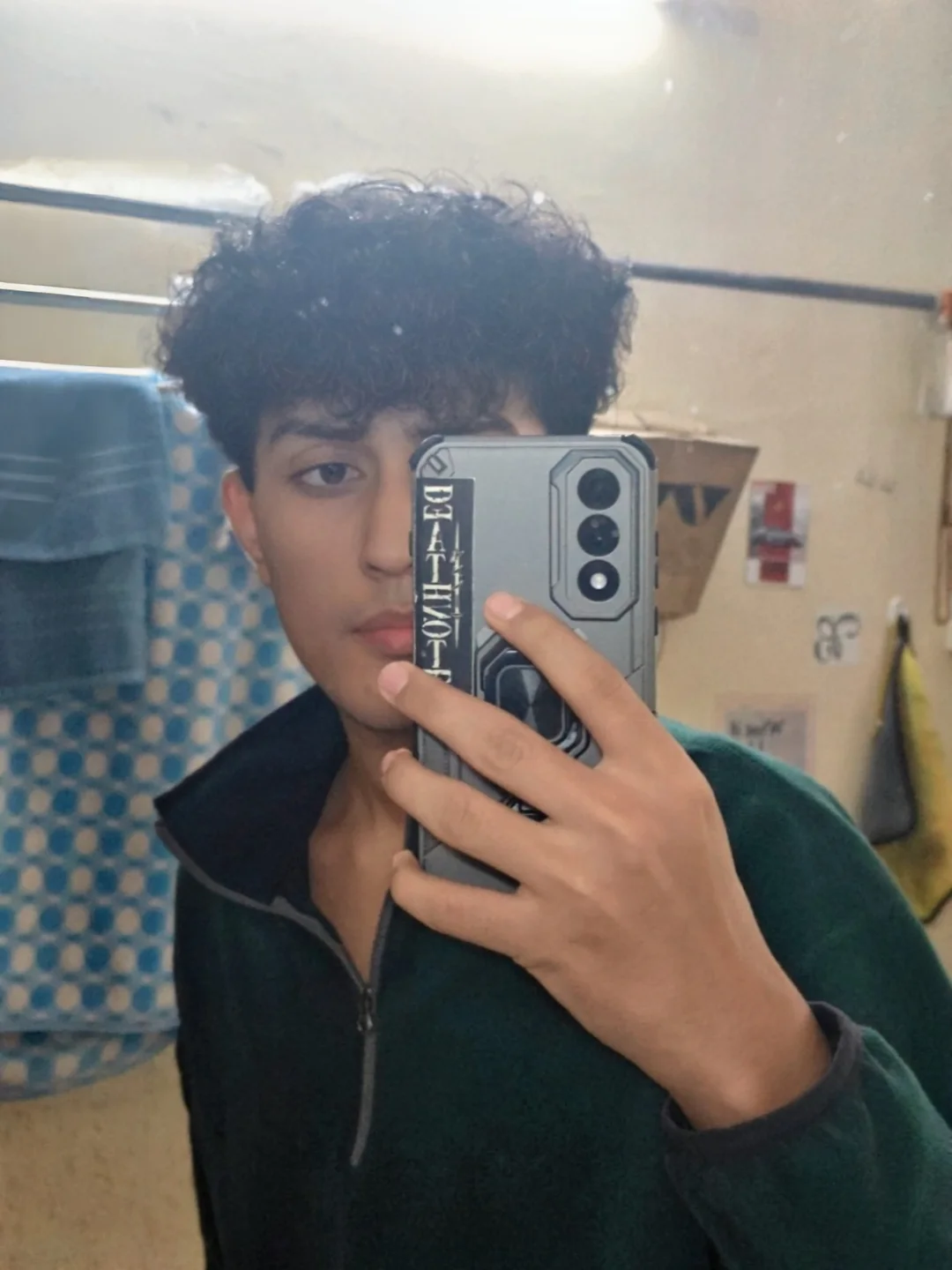 Aarush taking a mirror photograph in a dark jacket.